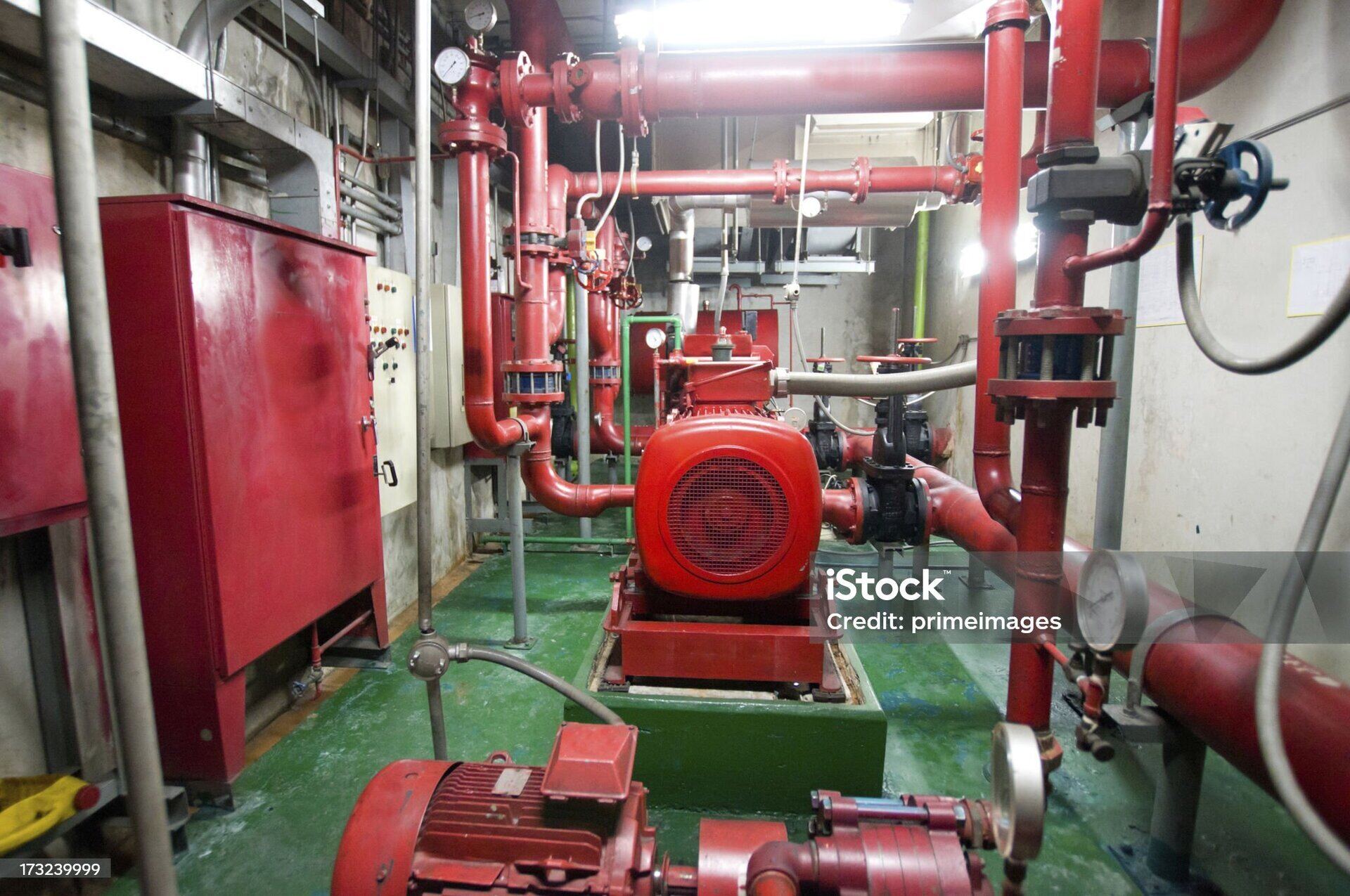 Fire safety pump room — red pipework and fire pump skid